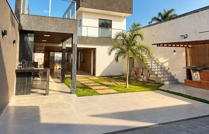 Fachada interna da casa do Mirante Experience com jardim e área gourmet
