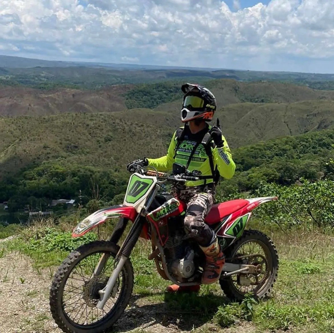 Piloto de motocross em trilha com vista para as montanhas