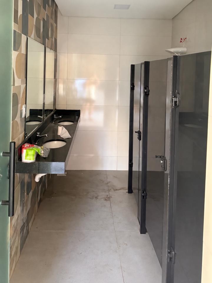 Banheiro feminino com bancada e cabines